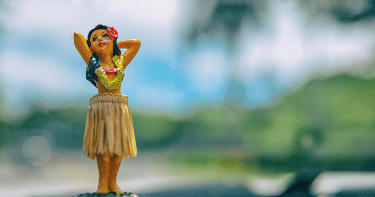ハワイアンフラガールのフィギュアが車のダッシュボードに置かれている。ボブルヘッド人形