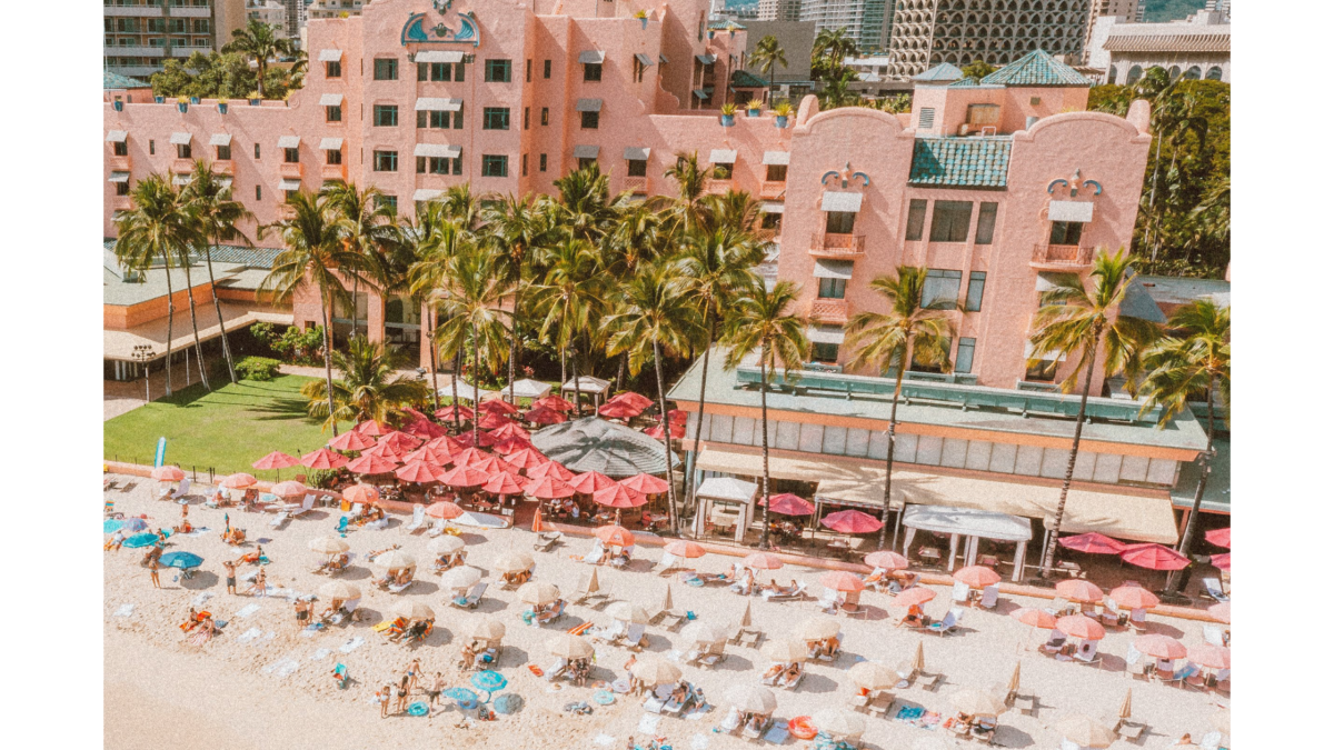 ピンク色のホテル近くにビーチで日光浴をしている人々